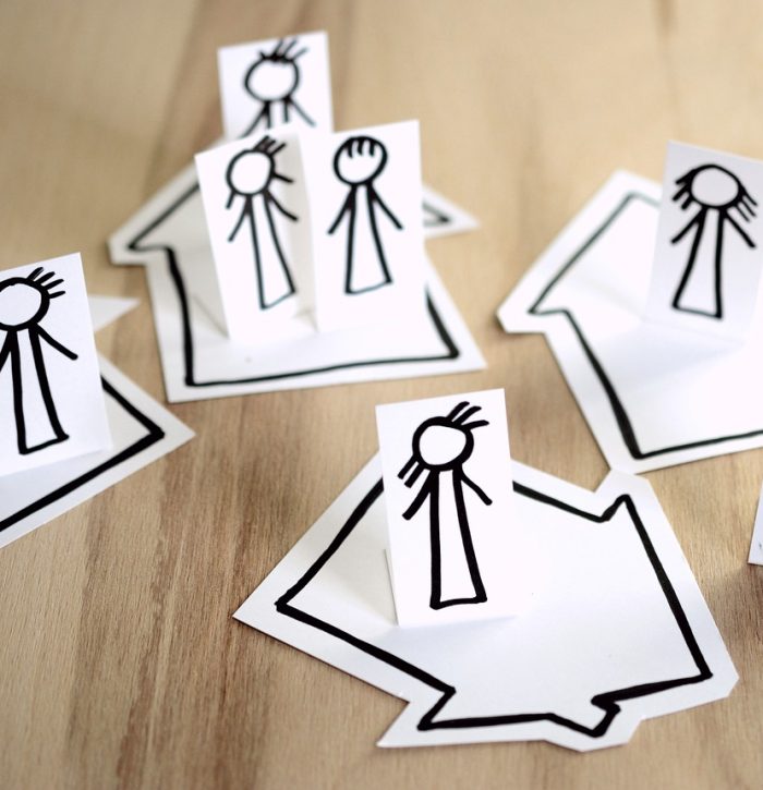 recortes de papel con dibujos simples de personas y casas en ellos